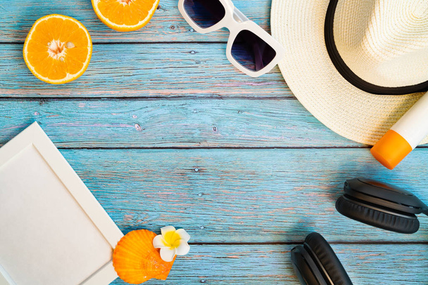Mooie zomervakantie, strandaccessoires, oranje, zonnebril, hoed en zonnebrandcrème op houten achtergronden - Foto, afbeelding