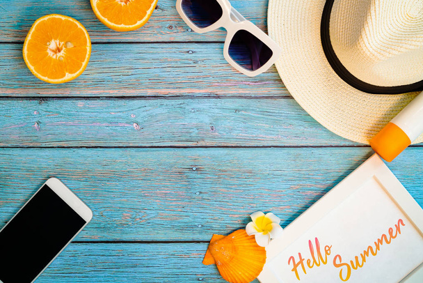 美しい夏休み、ビーチアクセサリー、オレンジ、サングラス、帽子、サンブロック、木製の背景のスマートフォン - 写真・画像
