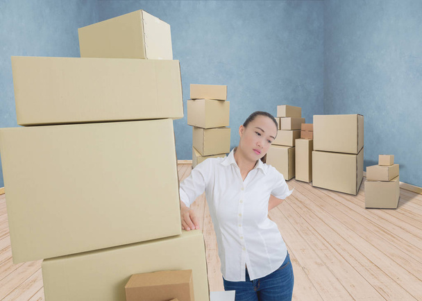 woman suffering from backache while moving boxes - Photo, image