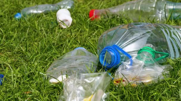 Plastic flessen liggen op het gras. - Video