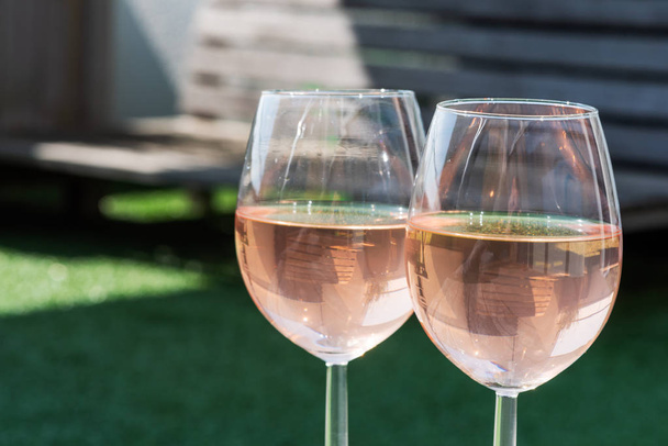 Two glasses of rose wine on a wooden table - Foto, imagen