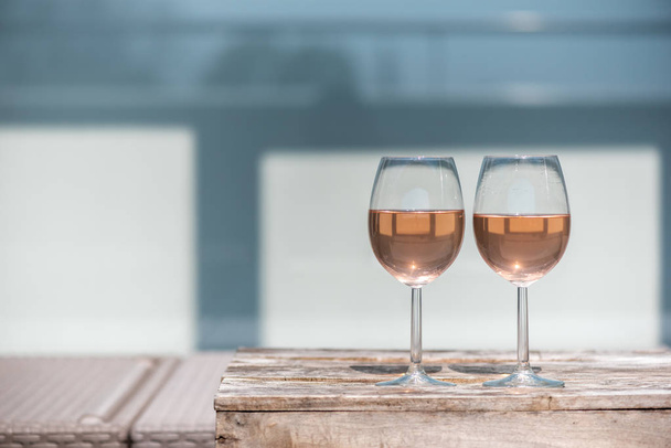 Two glasses of rose wine on a wooden table - Valokuva, kuva