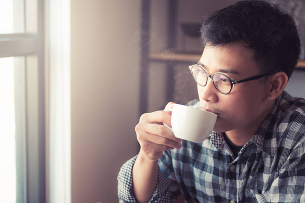Азиатский молодой человек, пьющий кофе в кафе., Как жить молодой азиатский бизнесмен в выходной деятельности отдыха с кофе. питьевая концепция
. - Фото, изображение