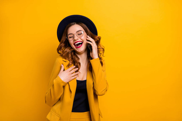 Close up photo beautiful funky she her lady arm hand telephone chat speak talk say tell friends relatives humor joke story wear specs formal-wear costume suit isolated yellow vibrant background - 写真・画像