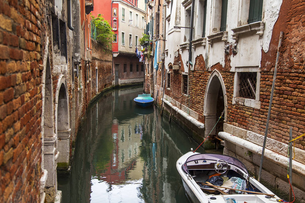 Venice, Italy, on April 25, 2019. Typical Venetian landscape. Street canal and old buildings ashore - Photo, image