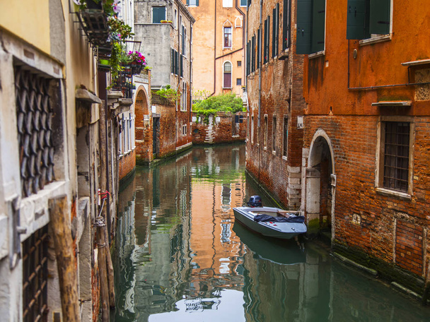 Venice, Italy, on April 25, 2019. Typical Venetian landscape. Street canal and old buildings ashore - Photo, image