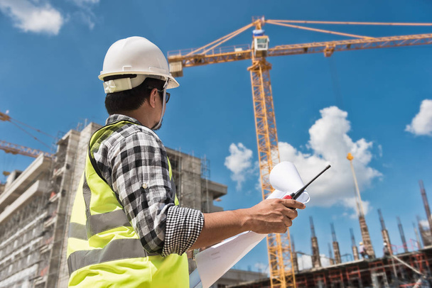 Ingénieur civil vérification des travaux avec dessin de construction sur le chantier de construction du bâtiment de grande hauteur
 - Photo, image