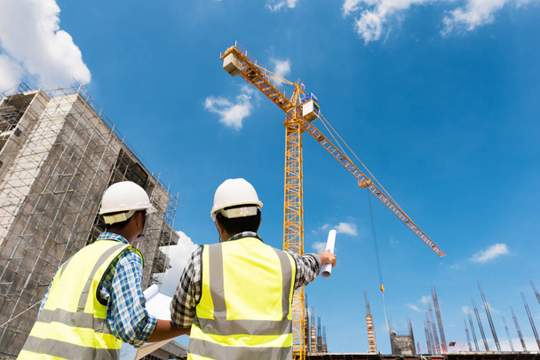 Обсуждение инженеров-строителей с архитекторами на строительной площадке или строительной площадке высотного здания
 - Фото, изображение