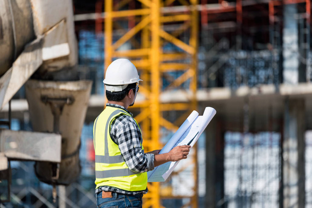 Engineering Consulting people on construction site holding blueprint in his hand. Building  inspector. Construction site check drawing and business workflow of new building - Photo, Image