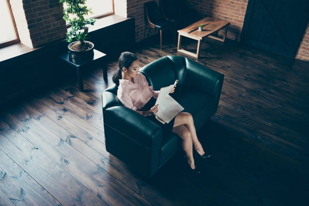 Above high angle view of nice attractive elegant confident lady skilled experienced expert sitting on comfortable couch reading economy news at modern industrial loft interior style work place station - Photo, Image