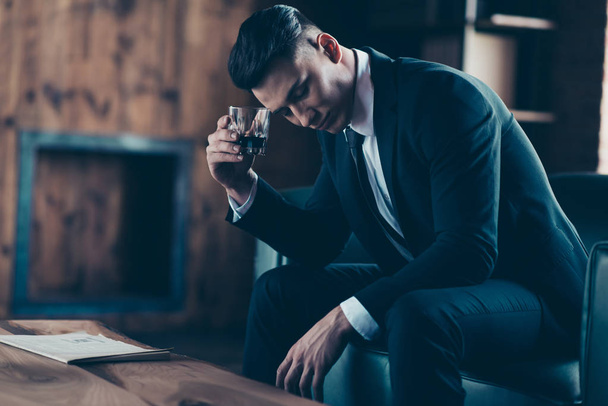 Close up side profile photo handsome he him his pensive ponder hands arms whisky beverage eyes closed enjoy wear formal-wear dress code shirt jacket tie suit costume sit chair indoors office place - Valokuva, kuva