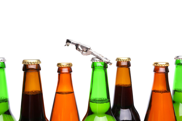bovenste flessen van bier en een opener - Foto, afbeelding