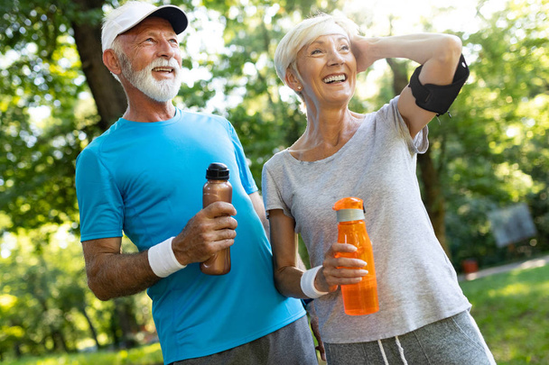 Senior couple staying hydrated after workout outdoor - Foto, afbeelding