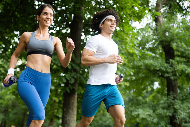 Couple friends jogging and running outdoors in nature - Foto, imagen