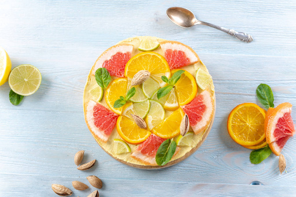 Raaka sitrushedelmäkakku greipillä, appelsiinilla, limetillä ja sitruunalla pähkinöillä ja mintulla. Terve tuore kesä vegaani jälkiruoka
 - Valokuva, kuva