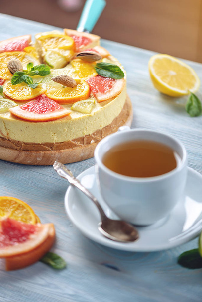 roher Zitruskuchen mit Grapefruit, Orange, Limette und Zitrone mit Nüssen und Minze. frisches Sommerdessert. glutenfreie vegane Kost - Foto, Bild