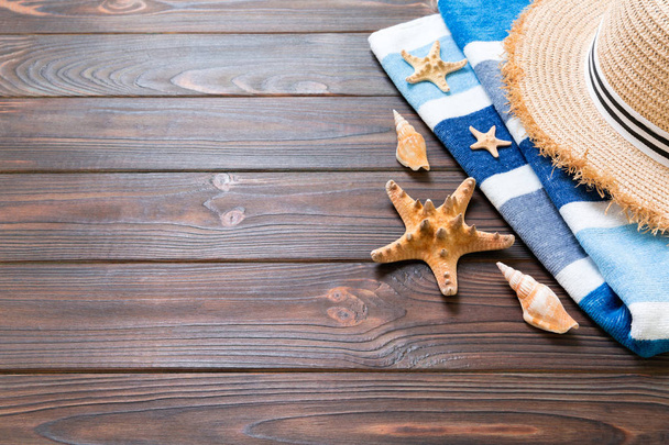 Olkihattu, sininen pyyhe ja meritähti tummalla puupohjalla. top view kesäloma käsite kopioi tilaa
 - Valokuva, kuva