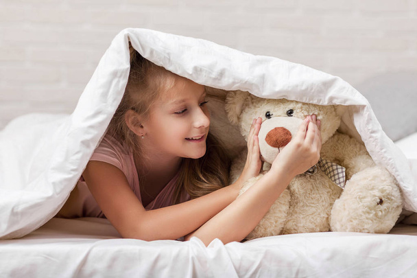 kleines Mädchen spielt mit Teddybär - Foto, Bild