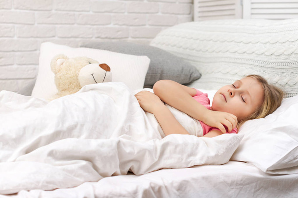 Cute little child girl sleeping with teddy bear - Фото, изображение