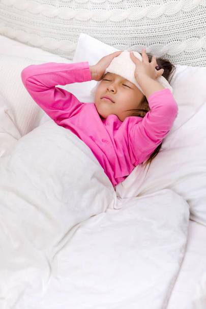 sick cold little child girl lies in bed - Valokuva, kuva