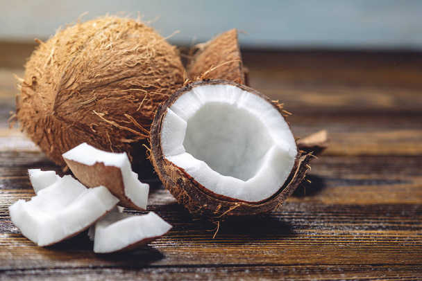 Open coconut with white pulp on wooden background. Organic healthy vegan product widely used in cosmetics - Foto, immagini