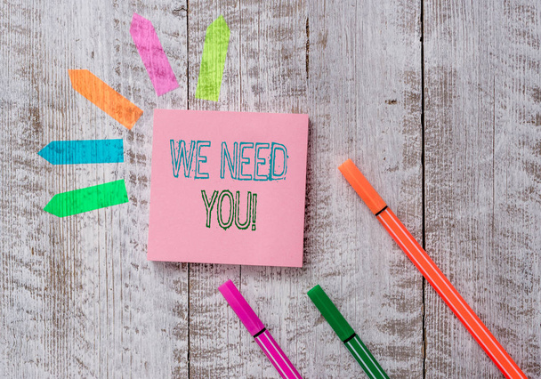 Text sign showing We Need You. Conceptual photo asking someone to work together for certain job or target Plain note paper and line arrow stickers on the top of wooden table desk. - Photo, Image