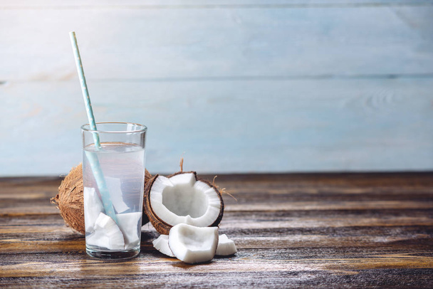 Kokosová voda ve složení s bílým masem na dřevěném podkladu. Organické výrobky široce používané v kosmetologii - Fotografie, Obrázek