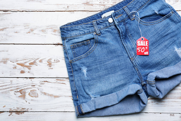 Шорти для джинсів з торговою маркою на білому дерев'яному фоні
 - Фото, зображення