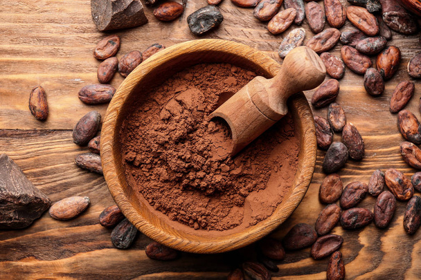 Bowl with cocoa powder on wooden background - Fotó, kép
