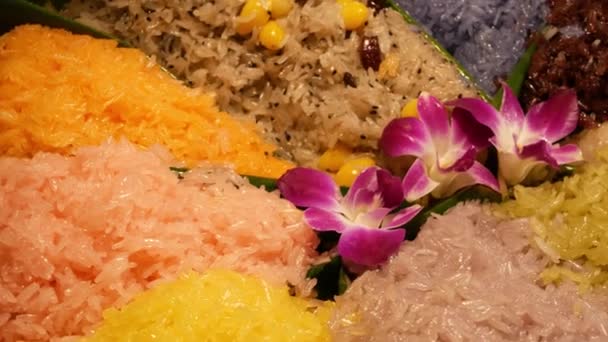 Exotic flowers on mango sticky rice. Closeup beautiful purple orchids placed on portion of colorful traditional Thai sticky rice dessert - Footage, Video