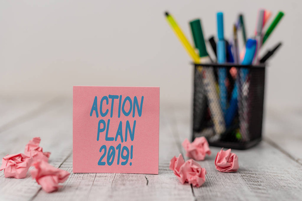 Text sign showing Action Plan 2019. Conceptual photo proposed strategy or course of actions for current year Set of plain note paper with scraps and stationary on the wooden table. - Photo, Image