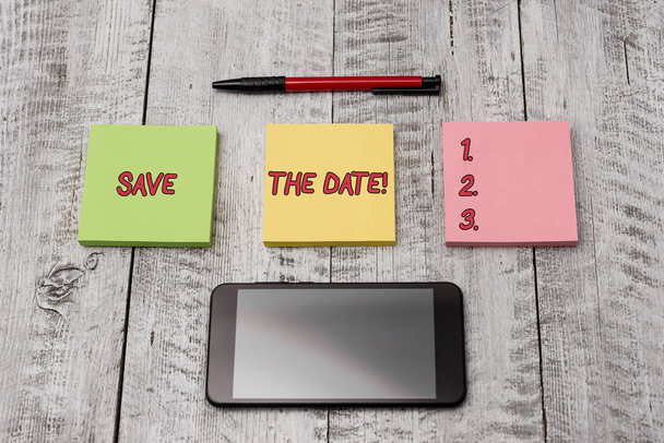 Writing note showing Save The Date. Business photo showcasing Organizing events well make day special event organizers Stationary equipment and phone with paper sheets on the wooden desk. - Photo, Image
