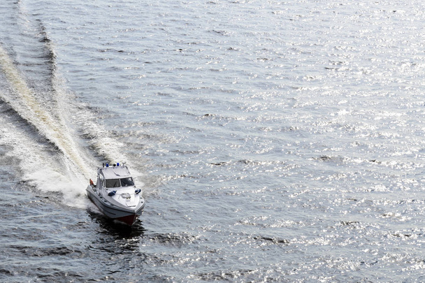Baltık Denizi 'nin dalgalarında beyaz kayık kurtarma operasyonu, suda güzel bir parıltı ve teknenin su lekeleri. - Fotoğraf, Görsel
