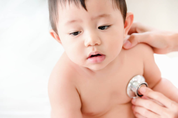 Uncomfortable face of Asian sick baby, Pediatrics doctor examining heartbeat and lungs of little baby boy with instruments stethoscope, Health care, Baby, Baby regular health check-up concept - Photo, Image
