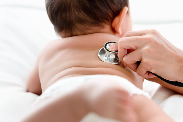Παιδιατρικός γιατρός που εξετάζει τον καρδιακό παλμό και τους πνεύμονες του μικρού αγοριού με τα όργανα στηθοσκόπιο, υγειονομική περίθαλψη, μωρό, μωρό, τακτική έλεγχος της υγείας ιδέα - Φωτογραφία, εικόνα