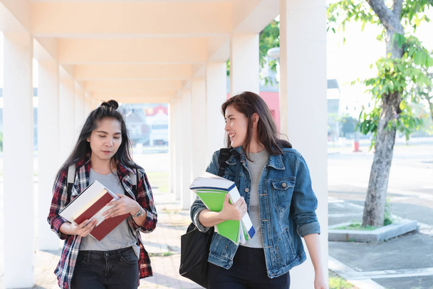 Deux femmes asiatiques, boursières Étudiants marchant avec le sourire dans le parc et discutant du dernier contenu du manuel à l'université après avoir appris en classe. Vie d "étude et d'amis
. - Photo, image