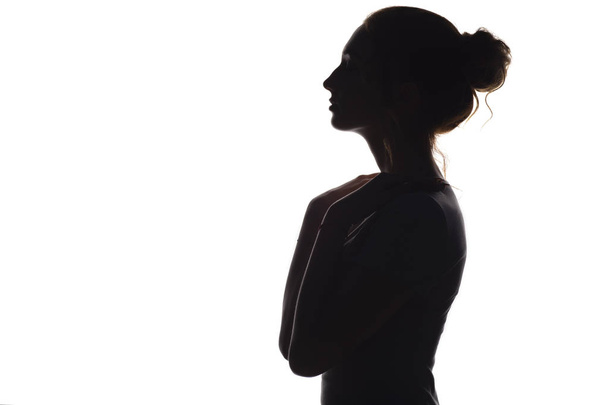 silueta de una joven mujer elegante sobre un fondo blanco aislado, el perfil de la cara de una hermosa chica
 - Foto, Imagen