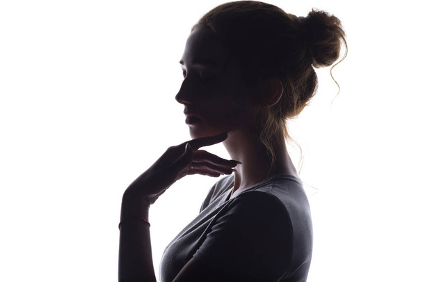 profil de belle fille aux cheveux cueillis à la main, silhouette d'une femme sur un fond blanc isolé
 - Photo, image
