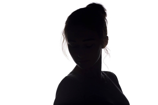 silhouette of young woman head with hairdo on a white isolated background - Фото, зображення