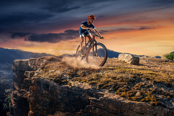 Maastopyöräilijä on jäljillä. Mies pyöräilijä ratsastaa kivellä
 - Valokuva, kuva