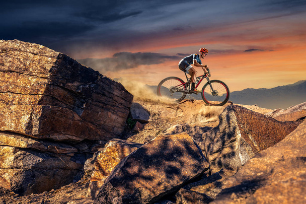 トレイル上のクロスカントリーバイカー。男性のサイクリストは岩に乗る - 写真・画像