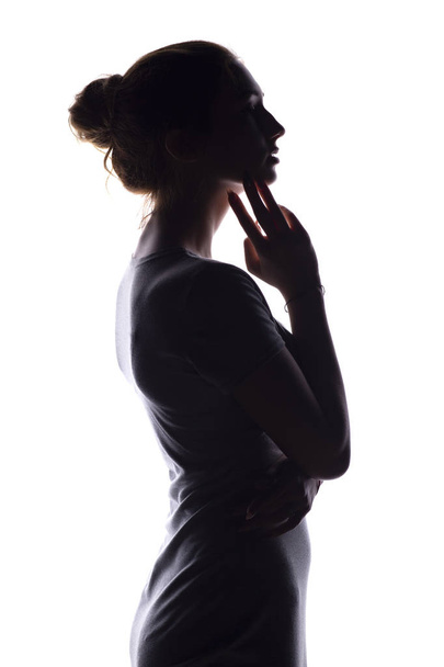 silhueta de uma jovem calma em um fundo isolado branco, figura de menina pensiva magro
 - Foto, Imagem