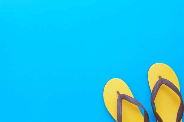 Vibrante moda juvenil retro plana yacía en la vista superior azul fondo textura concepto para la maqueta de producto de verano mínimo, diseño de traje de protección UV, conjunto de playa de color turquesa para vacaciones de fin de semana
. - Foto, imagen