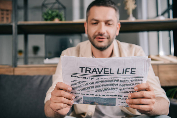 enfoque selectivo del hombre guapo leyendo el periódico de la vida de viaje
  - Foto, Imagen