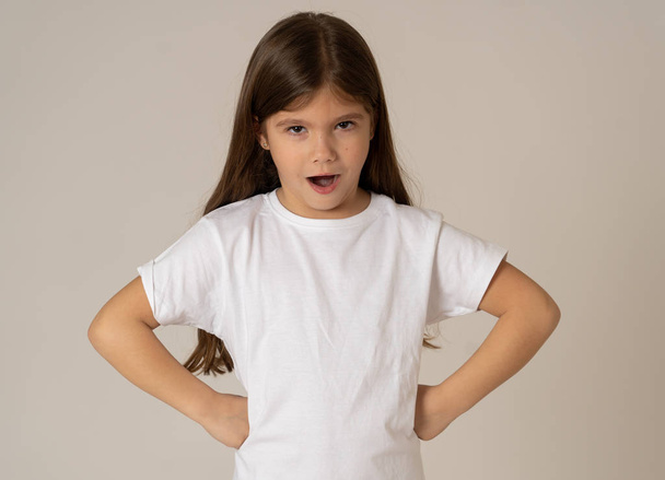 Portrait of a cute pretty child girl looking angry and disappointed with her arms crossed. Isolated on neutral background. In children feelings and behaviour and human emotions and expressions. - Photo, Image