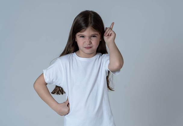 Close up portrait of a cute pretty child looking angry and disappointed pointing with finger against neutral background. In Children feelings and behavior and human emotions and expressions. - Φωτογραφία, εικόνα