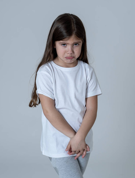 Portrait of a pretty young child looking unhappy and sad making funny cute facial expressions. Isolated on neutral background. Human emotions and children behaviour and feelings. - Photo, image