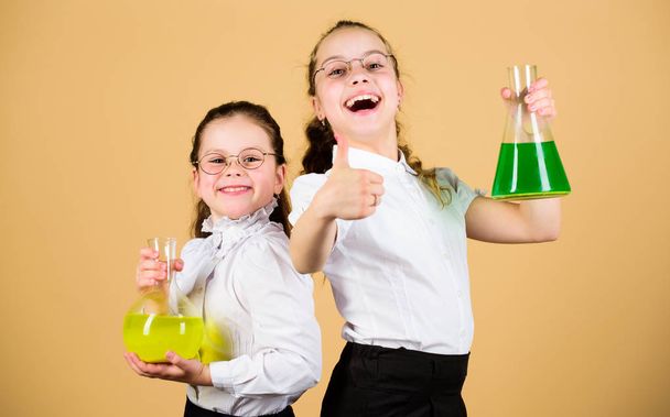 Fascinating experiment. Knowledge day. Schoolgirls friends with chemical liquids. Childhood and upbringing. Knowledge and information. Experimenting together. Education concept. Basic knowledge - Foto, Imagem