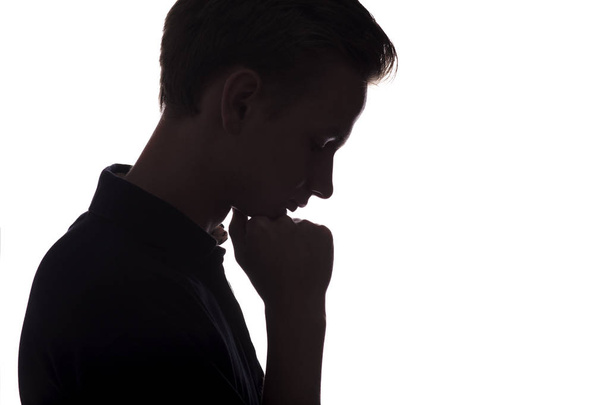 silhouette of guy bowed his head, man face profile on a white isolated background - Foto, Bild