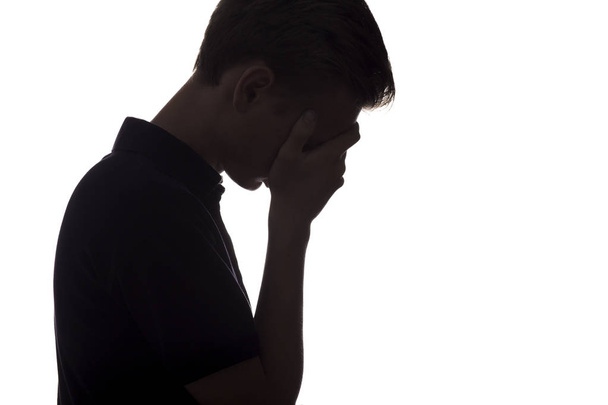 silhouet van een trieste kerel op een witte geïsoleerde achtergrond - Foto, afbeelding
